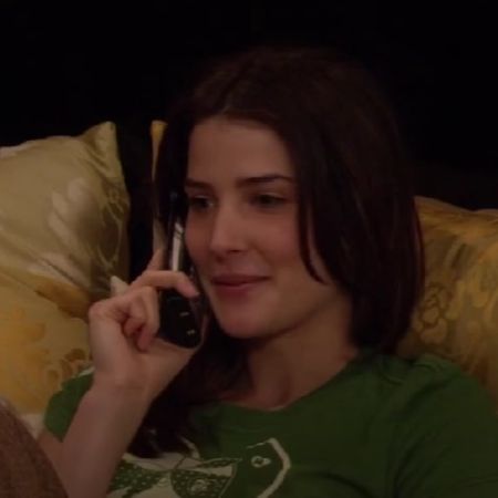 Cobie Smulders is on her bed talking on the phone.
